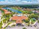 Overhead view of a community clubhouse, pool, and playground near a picturesque lake at 4558 Baleno Ln, Kissimmee, FL 34746