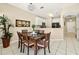 Dining area with a glass table, open to the kitchen, with modern lighting and a large plant at 4558 Baleno Ln, Kissimmee, FL 34746