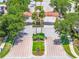 Community entrance with palm trees, landscaping, and a gatehouse on a sunny day at 4558 Baleno Ln, Kissimmee, FL 34746