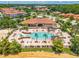 Aerial view of a community pool surrounded by lush greenery and palm trees, with lounge chairs and umbrellas at 4558 Baleno Ln, Kissimmee, FL 34746