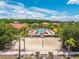 Aerial view of a pool surrounded by palm trees and a sand volleyball court on a sunny day at 4558 Baleno Ln, Kissimmee, FL 34746