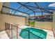 View of the screened-in pool and patio with view of the residences beyond the back fence at 4558 Baleno Ln, Kissimmee, FL 34746