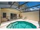 View of screened-in pool with steps, adjacent to covered patio, and view of residences behind at 4558 Baleno Ln, Kissimmee, FL 34746