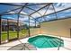 View of the screened-in pool and patio with view of the residences beyond the back fence at 4558 Baleno Ln, Kissimmee, FL 34746