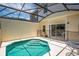 View of screened-in pool with steps, adjacent to covered patio, and view of residences behind at 4558 Baleno Ln, Kissimmee, FL 34746