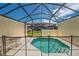 View of the screened-in pool with safety fence, table and chairs, and view of the other residences at 4558 Baleno Ln, Kissimmee, FL 34746