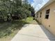 A backyard featuring a concrete patio, lush grass, and a view of the home's exterior at 4792 Summerfield Cir, Winter Haven, FL 33881