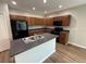 Well-lit kitchen with an island, black appliances, and wood cabinetry at 4792 Summerfield Cir, Winter Haven, FL 33881
