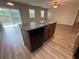 Kitchen island sink and view of a bright living area with sliding glass doors at 4792 Summerfield Cir, Winter Haven, FL 33881