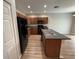 Open kitchen featuring an island with a sink, wood cabinets, and modern appliances at 4792 Summerfield Cir, Winter Haven, FL 33881