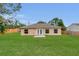 Cozy backyard featuring a small patio and a well-maintained lawn, perfect for outdoor relaxation and entertaining at 4836 Pierce Arrow Dr, Apopka, FL 32712