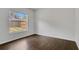 This bedroom features a window view, fresh white walls and complementary dark wood flooring at 4836 Pierce Arrow Dr, Apopka, FL 32712