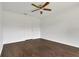 Bright bedroom featuring a ceiling fan, fresh white walls and complementary dark wood flooring at 4836 Pierce Arrow Dr, Apopka, FL 32712