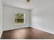 This bedroom features a window view, fresh white walls and complementary dark wood flooring at 4836 Pierce Arrow Dr, Apopka, FL 32712