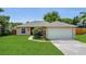 Charming single-story home with a well-maintained lawn, flowering bushes, and an attached two-car garage at 4836 Pierce Arrow Dr, Apopka, FL 32712