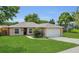 Inviting single-Gathering home with a manicured lawn, blooming landscaping, and an attached two-car garage, exuding curb appeal at 4836 Pierce Arrow Dr, Apopka, FL 32712