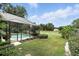 The pool area and backyard feature beautiful landscaping, a white fence, and a lush green lawn with mature trees at 518 Stephanie Ct, Lake Mary, FL 32746