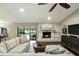 Spacious living room with a fireplace, ceiling fan, backyard views, and comfortable seating area at 518 Stephanie Ct, Lake Mary, FL 32746