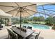 Outdoor dining set and grill next to a screen enclosed pool and patio area at 518 Stephanie Ct, Lake Mary, FL 32746