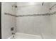 Close up of bathtub shower with tile surround and horizontal decorative accent at 518 Stephanie Ct, Lake Mary, FL 32746