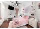 Charming bedroom featuring light pink decor, a ceiling fan, a mounted TV, and bright accents at 538 Majestic Oak Dr, Apopka, FL 32712