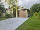 Charming one-story home with a well-manicured lawn and a two-car garage and palm tree at 679 Midori St, Orlando, FL 32811