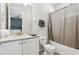 Clean bathroom featuring granite vanity, tile flooring, and tub shower with light gray shower curtain at 7456 Marker Ave, Kissimmee, FL 34747