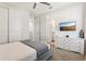 Comfortable bedroom with TV, light walls, view to bath, and light gray throw blanket at 7456 Marker Ave, Kissimmee, FL 34747