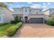 Beautiful two-story home with a brick driveway and a well-manicured front lawn at 7456 Marker Ave, Kissimmee, FL 34747