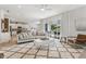 Open-concept living room features a large sofa, stylish rug, and access to outdoor patio at 7456 Marker Ave, Kissimmee, FL 34747