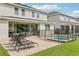 A covered patio with outdoor furniture overlooks a screened-in pool and grassy lawn at 7456 Marker Ave, Kissimmee, FL 34747