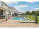 Relaxing backyard pool and hot tub area surrounded by a brick patio and safety fence at 7456 Marker Ave, Kissimmee, FL 34747