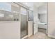Modern bathroom featuring a glass-enclosed shower with neutral tile and a view into the bedroom at 7456 Marker Ave, Kissimmee, FL 34747