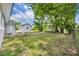 Spacious backyard with blue sky, lush trees, and blue trim utility shed at 7601 Aviano Ave, Orlando, FL 32819