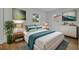 Beautifully staged main bedroom with bright white walls, art, wood floors and multiple windows at 7601 Aviano Ave, Orlando, FL 32819