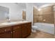 A bathroom featuring a double vanity and a bathtub with glass doors at 8192 Boat Hook Loop # 205, Windermere, FL 34786