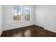 A bedroom featuring dark wood floors and a view of nearby buildings through the window at 8192 Boat Hook Loop # 205, Windermere, FL 34786
