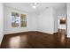 A bedroom with dark wood floors and a ceiling fan, offering a peek into the kitchen at 8192 Boat Hook Loop # 205, Windermere, FL 34786
