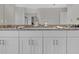 A bathroom with double vanity, granite countertops, and white cabinets at 11158 Hollow Bay Dr, Winter Garden, FL 34787