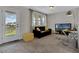 Bright living area featuring a plush sofa, ottoman, and a functional desk space near a balcony door at 11158 Hollow Bay Dr, Winter Garden, FL 34787