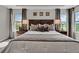 Cozy bedroom with a large bed, wooden headboard, soft lighting, and windows offering scenic views at 11158 Hollow Bay Dr, Winter Garden, FL 34787