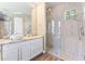 The primary bathroom has a walk-in shower with a window, dual sinks, granite counters, and white cabinetry at 11333 Camden Park Dr, Windermere, FL 34786