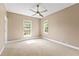 Spacious bedroom with large windows, a ceiling fan, and neutral carpeting at 11333 Camden Park Dr, Windermere, FL 34786