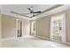 Spacious bedroom featuring three bright windows, a ceiling fan, and plush carpeting at 11333 Camden Park Dr, Windermere, FL 34786