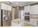 A modern kitchen features stainless appliances, granite counters, and custom white cabinetry at 11333 Camden Park Dr, Windermere, FL 34786