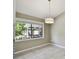 Bright dining area with a modern pendant light fixture and a large window offering a view of the landscaped yard at 116 Morning Glory Dr, Lake Mary, FL 32746
