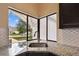 Close-up of the kitchen sink area, featuring granite countertops, a modern faucet, and a view of the neighborhood at 116 Morning Glory Dr, Lake Mary, FL 32746