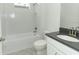 Well-lit bathroom features a shower-tub combo and a vanity with a gray countertop and silver fixtures at 1328 Lombardi Ct, Poinciana, FL 34759