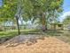 Inviting backyard with tile patio, mature trees, lush grass, and a storage shed at 1328 S Oxalis Ave, Orlando, FL 32807