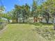 Beautiful backyard featuring a lush lawn, mature trees, and a storage shed on a sunny day at 1328 S Oxalis Ave, Orlando, FL 32807